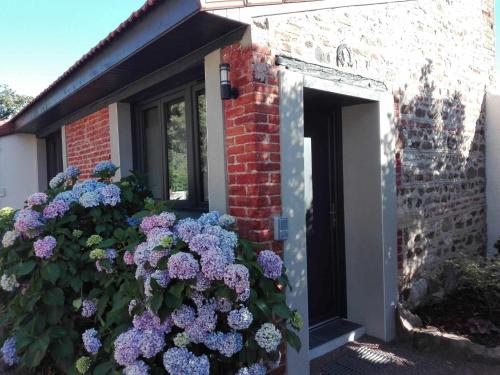 a bunch of purple flowers in front of a door at Micro Maison indépendante in Commelle-Vernay