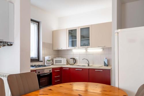 a kitchen with red cabinets and a wooden table at Casa 1207 in Caleri