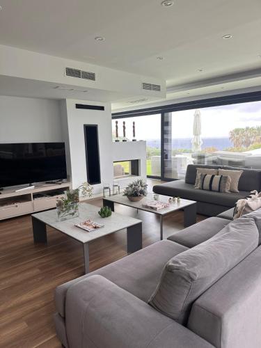 a living room with couches and tables and a tv at Villa Essencia in Zahara de los Atunes