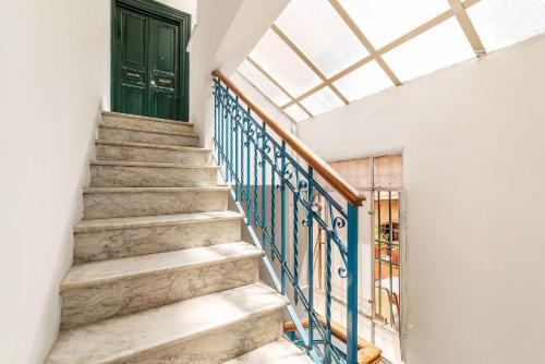 a staircase with a green door and a window at Terrazza di Flamy - WelcomeToRhome in Rome