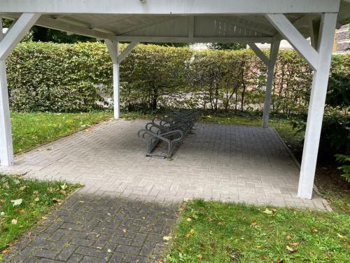 a bench sitting under a pavilion in a park at Haus am Buchenpark 02 in Neuhof