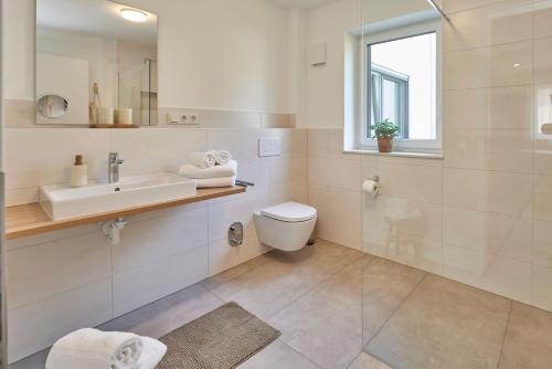 a white bathroom with a sink and a toilet at Neu!!! Moselbleibe Weingartenhaus in Bernkastel-Kues