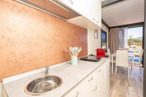 a kitchen with a sink and a dining room at Hoceanika Houseboat Porto Rotondo in Porto Rotondo