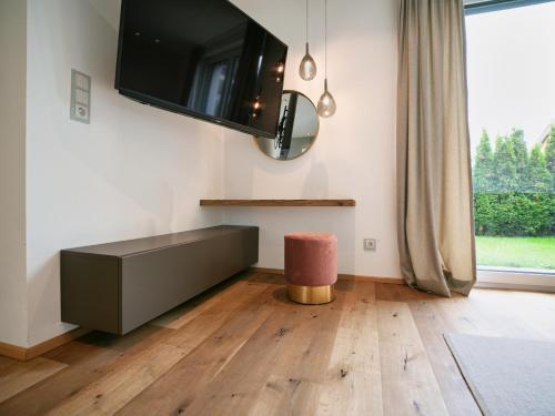a living room with a tv on the wall at HEAVEN 7 SUITE - Garden Apartment with Private Whirlpool in Zillertal, presented by AlpenLuxus in Fügen