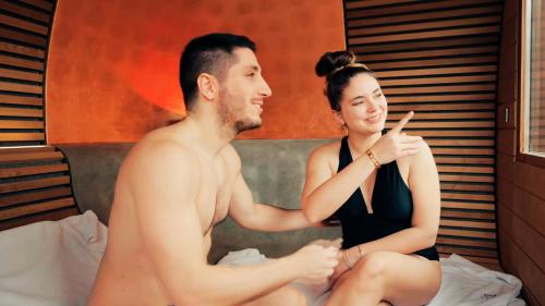 a man and a woman sitting on a bed at T'AMI Hotel Resort Spa in Selvino