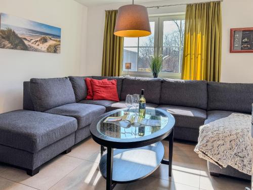 Una sala de estar con un sofá y una mesa de cristal. en Windland, en Zingst