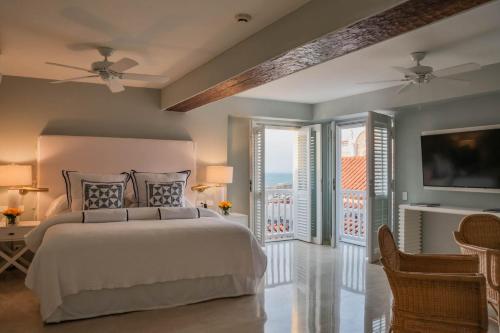 a bedroom with a large bed and a balcony at Casa La Merced by Mustique in Cartagena de Indias