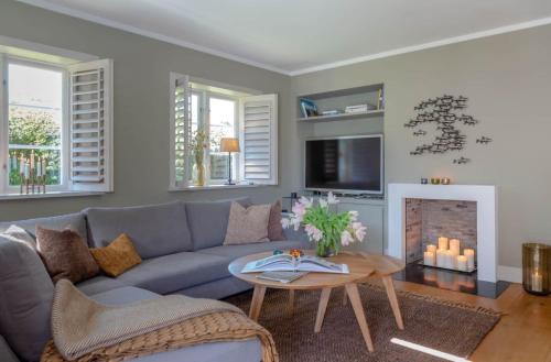 a living room with a blue couch and a fireplace at Kampenherz - Traumhaftes Einzelhaus im Herzen von Kampen in Kampen