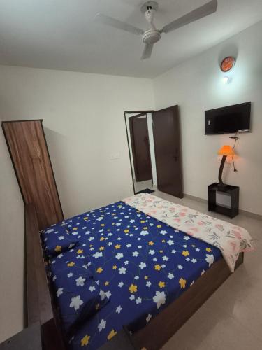 a bedroom with a bed with a blue comforter at Signature Gurgaon House 89 in Gurgaon