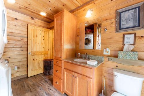 a log cabin bathroom with a sink and a toilet at critter corner at Grant Summit Cabins in Bryant