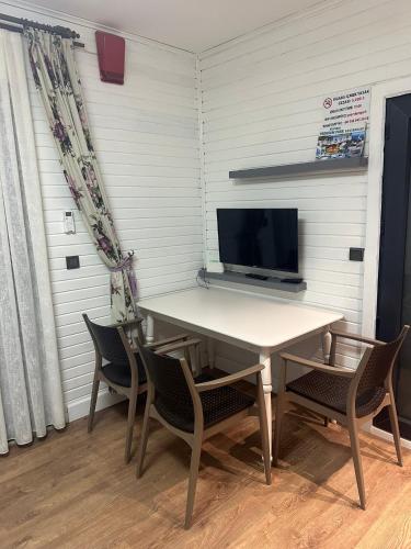 a table and chairs in a room with a television at premium park apart otel in Kemer