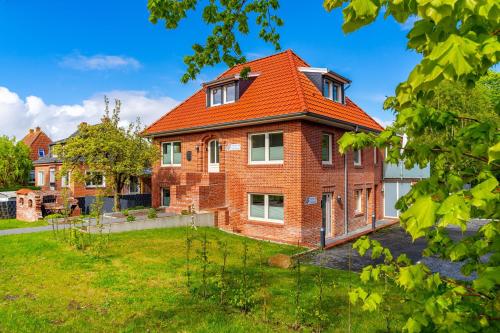 una casa in mattoni con tetto arancione di Die Zimmerei 3, zentrale Lage, Dachgeschoss mit Balkon und Klimaanlage! a Greetsiel