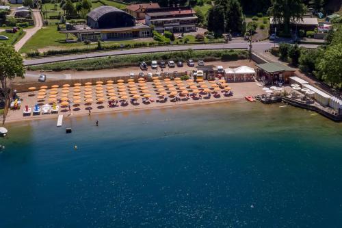 an aerial view of a beach with umbrellas and the water at Casa Luzi Appartamento Vista Lago Orta in Ameno