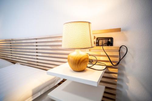 a lamp sitting on a table in a bedroom at Casa Luzi Appartamento Vista Lago Orta in Ameno