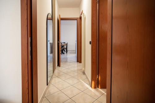 a hallway with two mirrors and a tile floor at Casa Luzi Appartamento Vista Lago Orta in Ameno