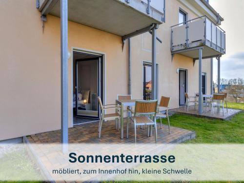 a balcony with a table and chairs on a patio at Peenemünde, Seglerhafen ST Brig 02 & 04 in Peenemünde