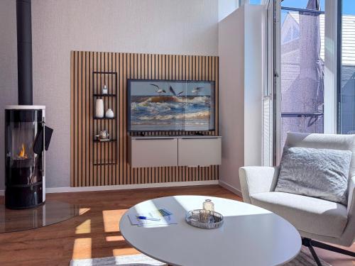 sala de estar con mesa, sofá y silla en Kraanstiet 2, en Zingst