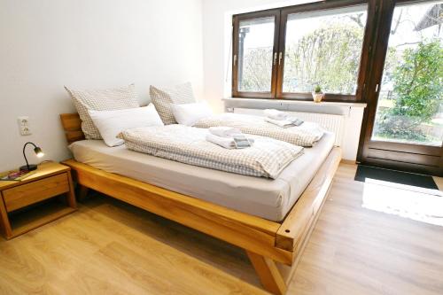 a bed in a room with a large window at Winklstüberl in Grabenstätt