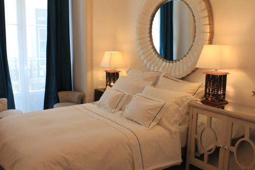 a bedroom with a large white bed with a mirror at Lisbon Downtown Inn in Lisbon