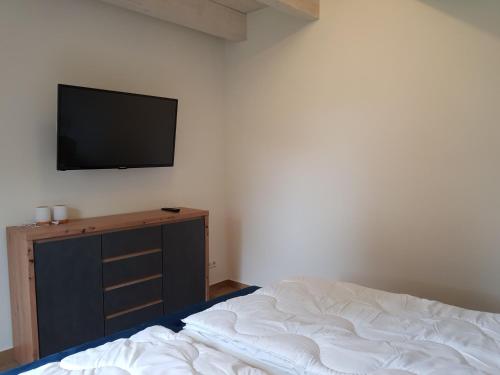a bedroom with a bed and a tv on a wall at Ferienhaus Max in Rerik