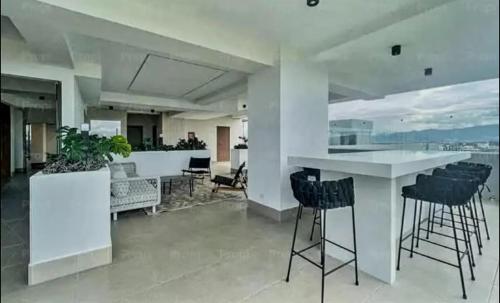 a kitchen with a bar with black stools at Apartamento con Piscina de 2 habitaciones Edificio Brunelo Ciudad de Guatemala, Céntrico in Estación Pamplona