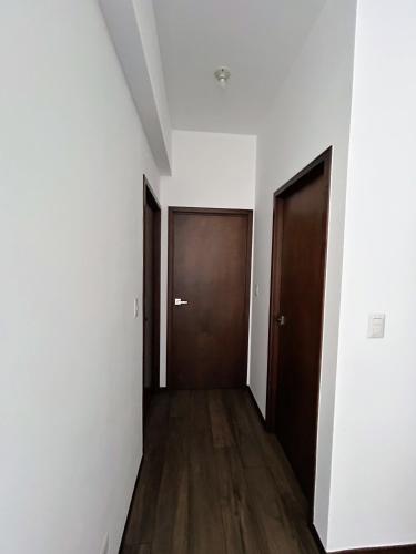 an empty hallway with two doors and wooden floors at Apartamento con Piscina de 2 habitaciones Edificio Brunelo Ciudad de Guatemala, Céntrico in Estación Pamplona