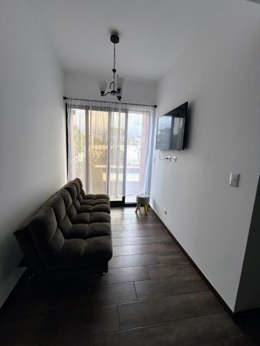 a living room with a couch and a television at Apartamento con Piscina de 2 habitaciones Edificio Brunelo Ciudad de Guatemala, Céntrico in Estación Pamplona
