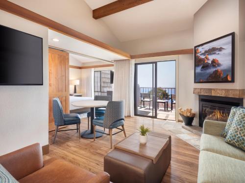 a living room with a fireplace and a table and chairs at Hyatt Vacation Club At Highlands Inn in Carmel
