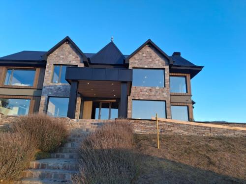 a house with a black roof on a hill at Ayres de Calafate in El Calafate