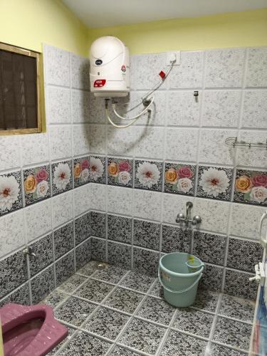 a bathroom with a shower with a bucket in it at Yal Homestay in Yercaud