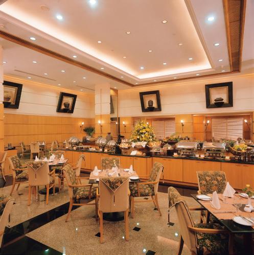 a dining room with tables and chairs in a restaurant at The Fern-An Ecotel Hotel, Kochi in Cochin