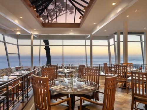 a restaurant with tables and chairs with the ocean in the background at Hyatt Vacation Club At Highlands Inn in Carmel
