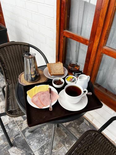 Hostal Malú في سان بيدرو دي أتاكاما: طاولة عليها طبق لحم وفنجان قهوة
