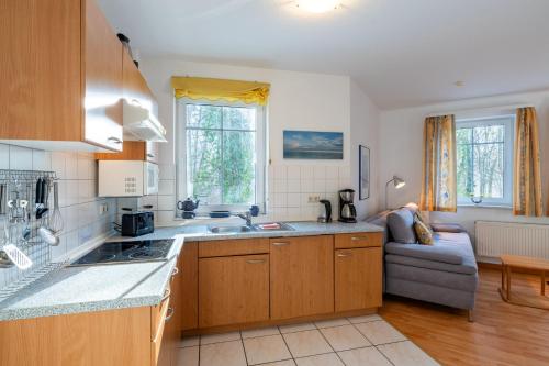 une cuisine avec un évier et un canapé dans une chambre dans l'établissement Haus am Buchenpark 09, à Neuhof