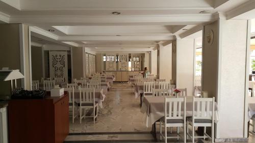 a banquet hall with white tables and white chairs at Halıcı Hotel Marmaris in Marmaris