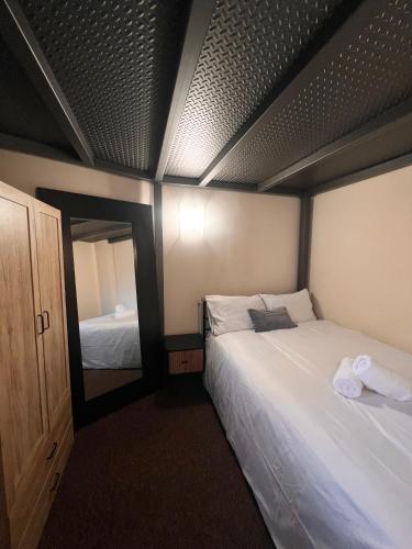 a bedroom with two beds and a large mirror at Cityscape condos in Dewsbury