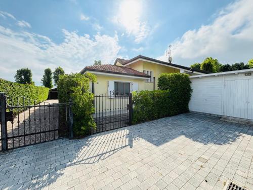 a house with a gate in front of a driveway at Diamante in Isola Albarella