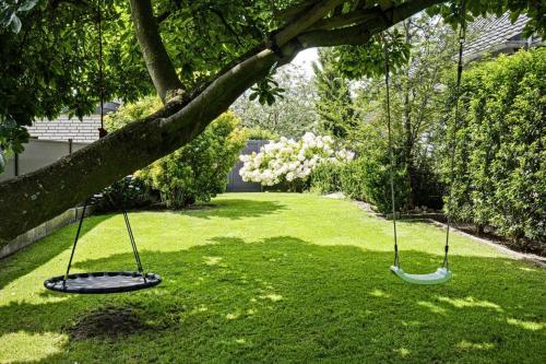 two swings hanging from a tree in a yard at Ferienwohnung Ida in Xanten