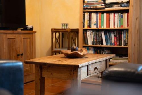 a table with a hat on top of it next to a book shelf at Toscana in Isola Albarella