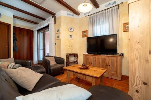 a living room with a couch and a tv at Toscana in Isola Albarella