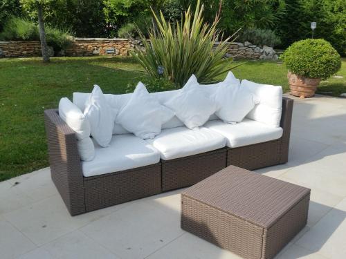 a brown wicker couch with white pillows on a patio at Lydia in Palazzo Vianello