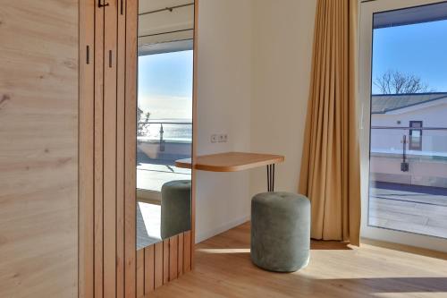 a room with a table and a stool next to a window at Villa Am Stadthafen - 200m zur Ostsee in Sassnitz