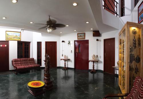 a living room with a couch and a ceiling fan at Pondicherry Executive Inn in Puducherry
