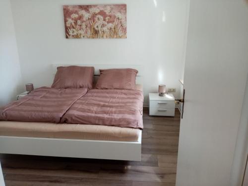 a bedroom with a bed with a painting on the wall at Ferienwohnungen Evers 55181 in Stallbrüggerfeld