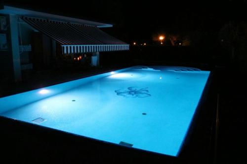 a large swimming pool lit up at night at Francesca in Isola Albarella