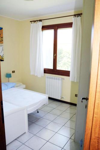 a bedroom with two beds and a window at Francesca in Isola Albarella