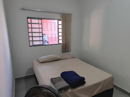 a small bed in a room with a window at Suítes quintino in Uberlândia