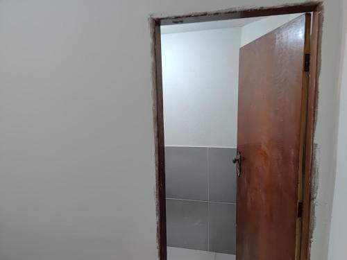 a bathroom with a mirror and a shower door at Suítes quintino in Uberlândia