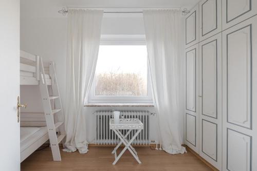 a white room with a ladder and a window at App Meerzeit in List
