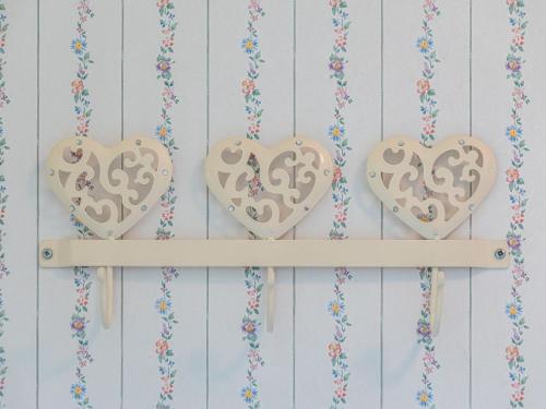 three wooden hearts hanging on a wall with flowers at Kornblume_DH in Groß Kelle